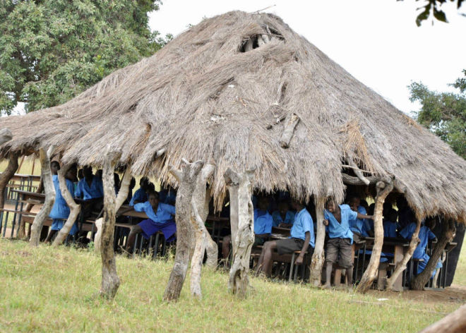 Strohgedeckte Hütte, die Schule, mit Schulkindern drin